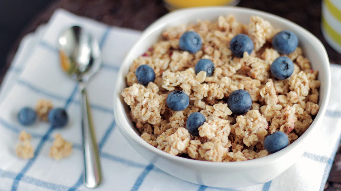 Bowls of whole grains, seeds, and fresh produce arranged on a wooden table