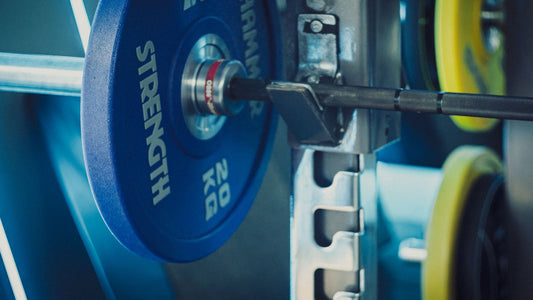 Athlete loading plates onto a barbell in a gym