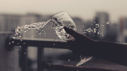 Cold water being poured into a clear glass on a kitchen counter