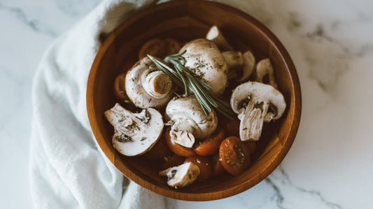 Dried mushrooms and powder arranged in a wooden bowl on a table