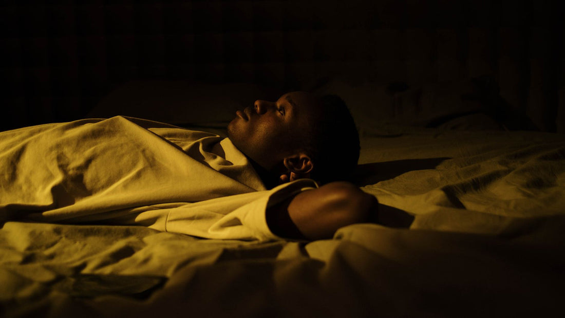 Dimly lit bedroom with a made bed at night